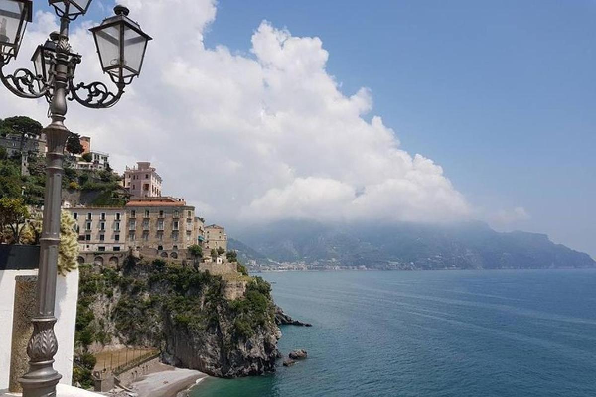 a street light next to the ocean with a mountain