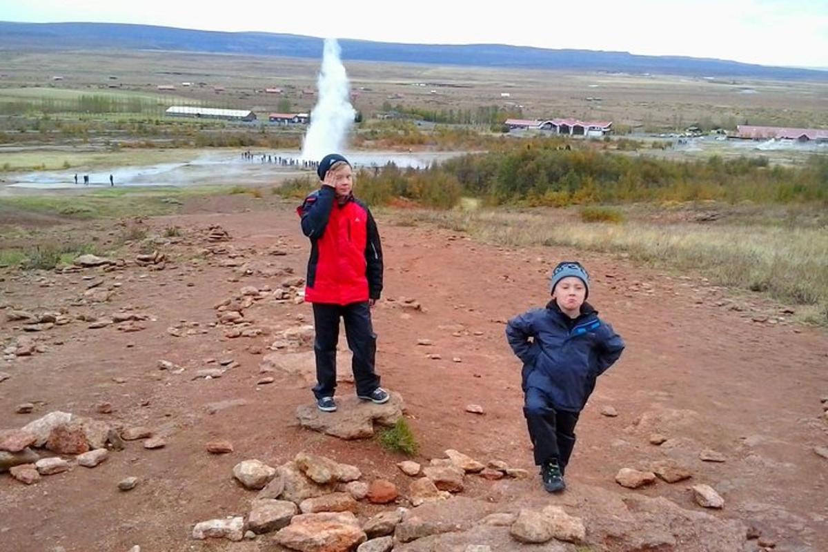 due uomini sono in piedi su una strada sterrata con un geyser