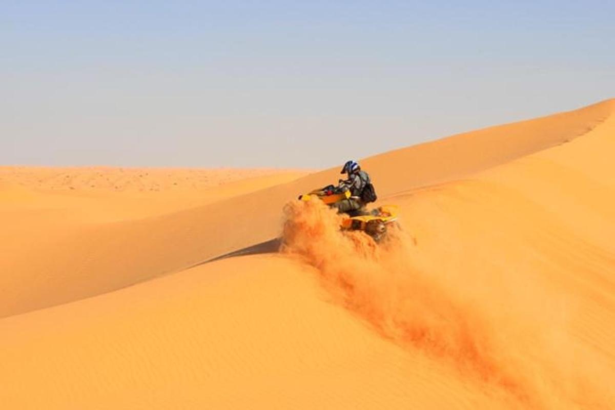 uma pessoa andando de quadriciclo no deserto