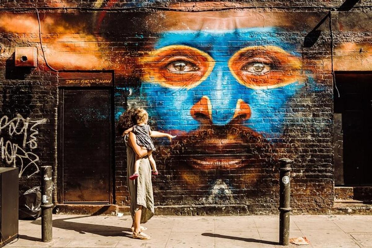 una donna in piedi davanti a un muro con un murale