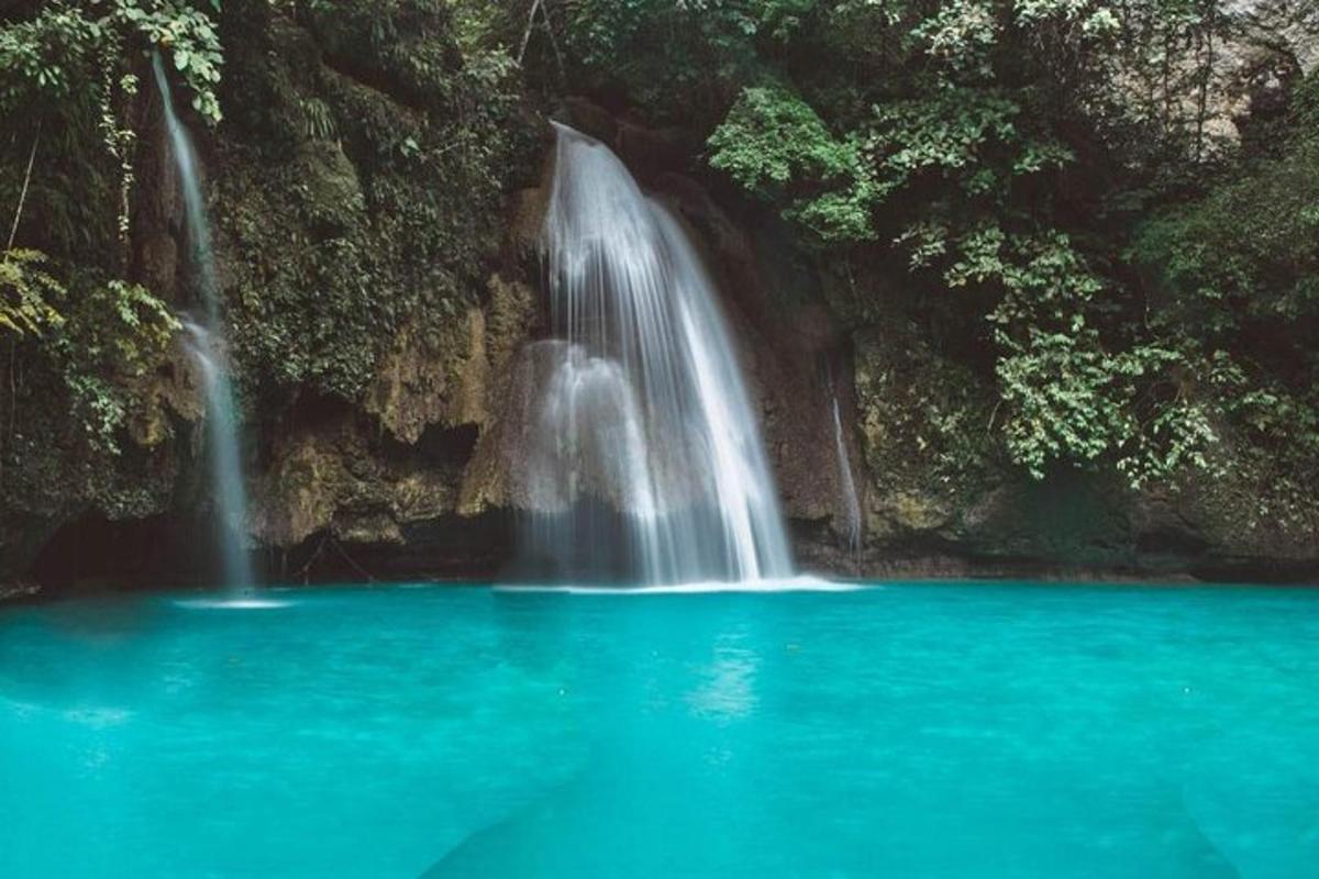 une cascade au milieu d'un bassin d'eau bleue