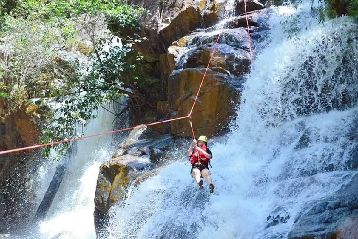 um homem em uma corda em frente a uma cachoeira