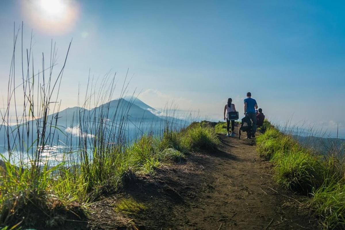 um grupo de pessoas andando de bicicleta em uma trilha com vista para a água