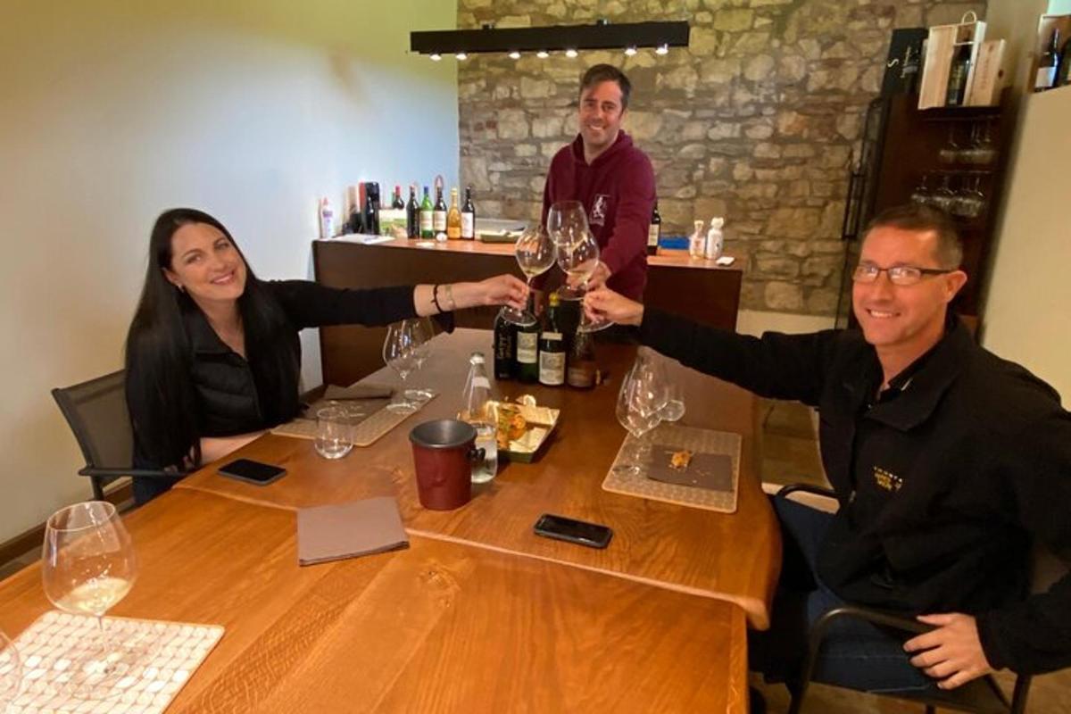 Un grupo de personas sentadas alrededor de una mesa con copas de vino.