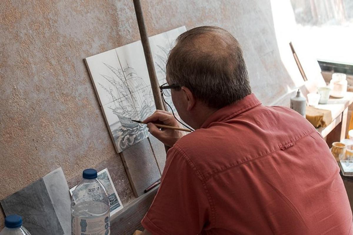 un home pintant un quadre sobre un llenç