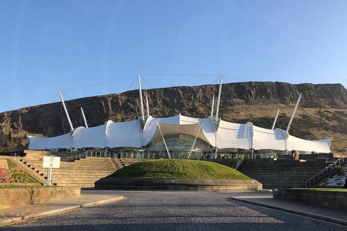 un gran edifici blanc amb una muntanya al fons