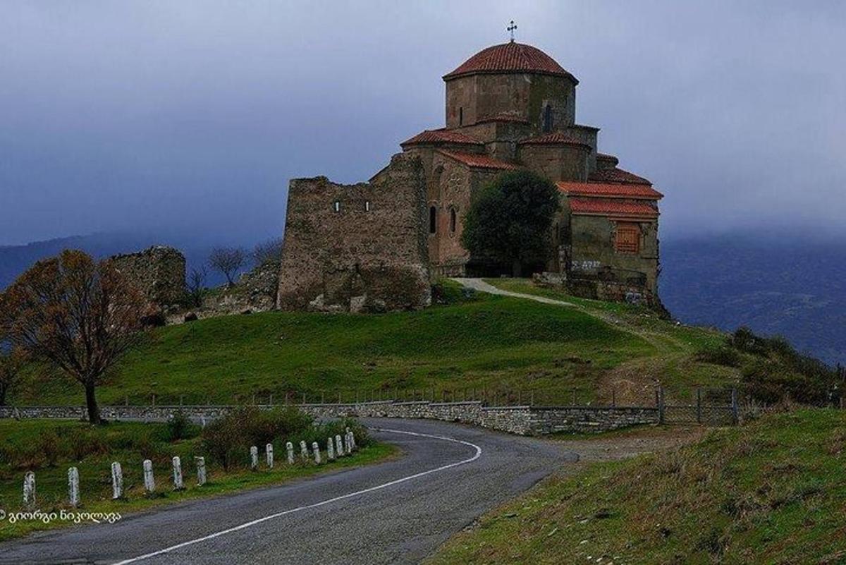budova na vrcholu kopce s cestou