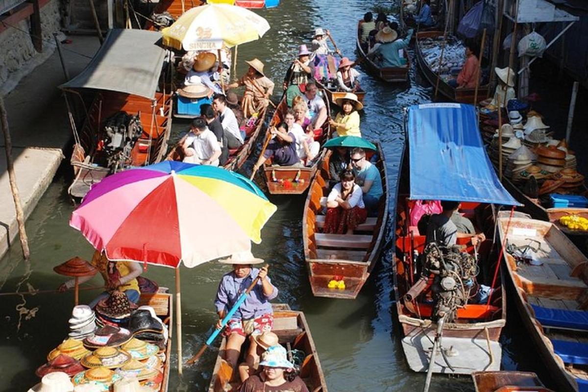 a group of people on boats in the water with umbrellas