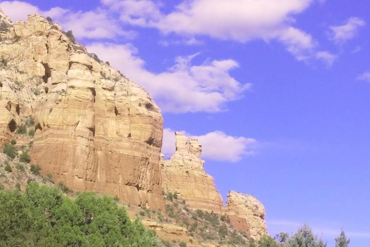 una montagna rocciosa con cielo azzurro e nuvole