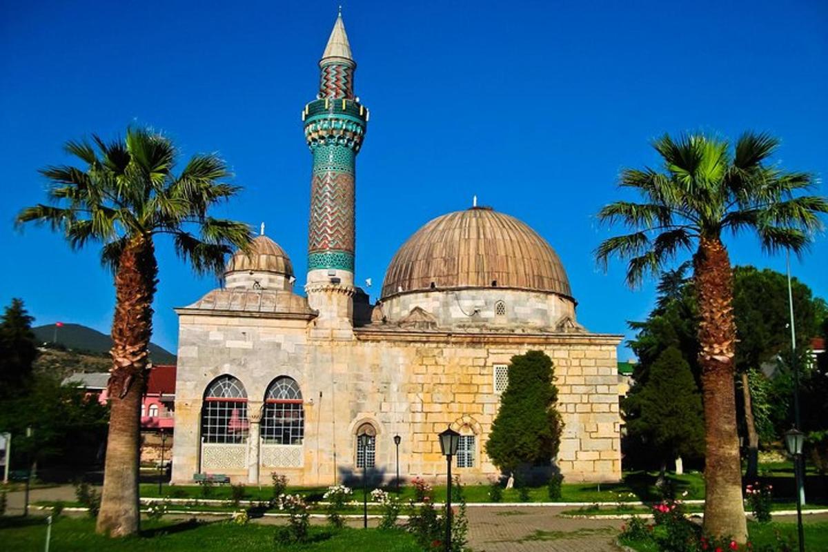 egy mecset, tetején minarettel és pálmafákkal