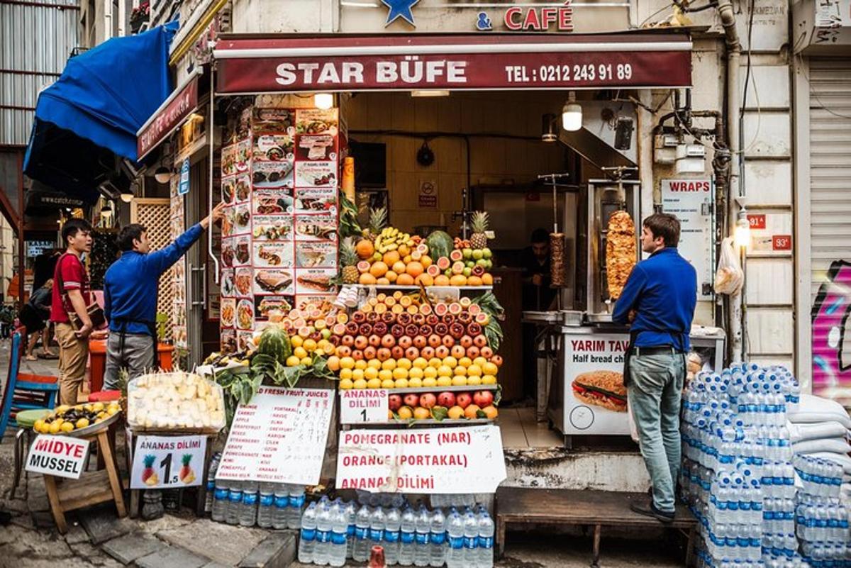 Dos hombres están parados frente a un puesto de frutas.