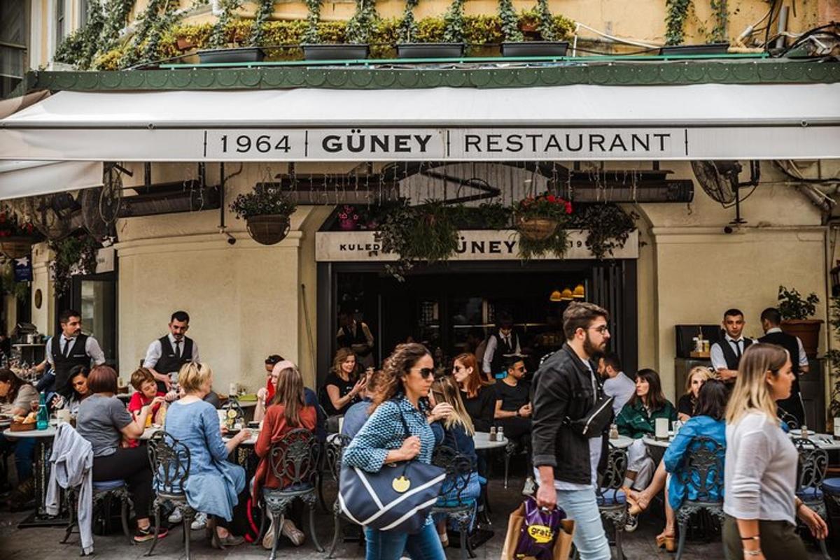 skupina lidí sedících u stolů před restaurací
