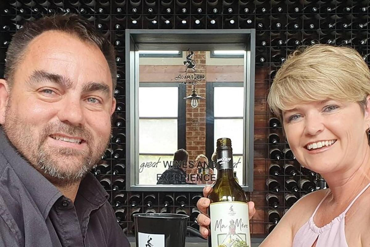 a man and a woman holding a bottle of wine