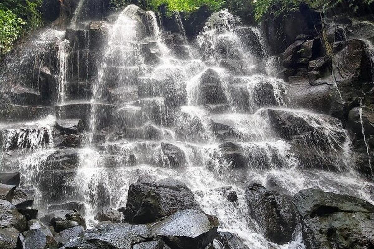 a waterfall on the side of a mountain with rocks