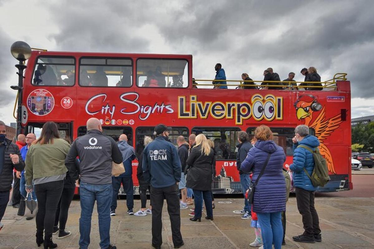 a group of people standing in front of a double decker bus