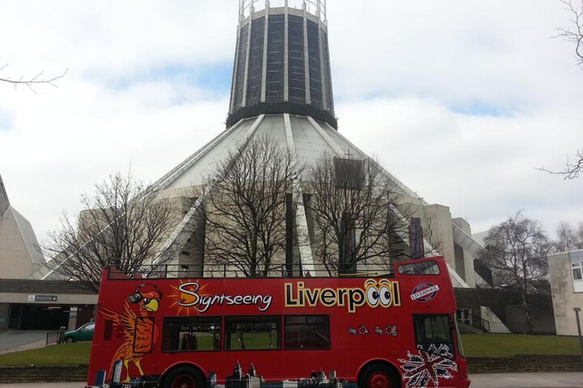 a red double decker bus parked in front of a tower