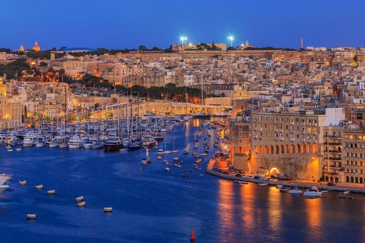 a city with boats in a harbor at night