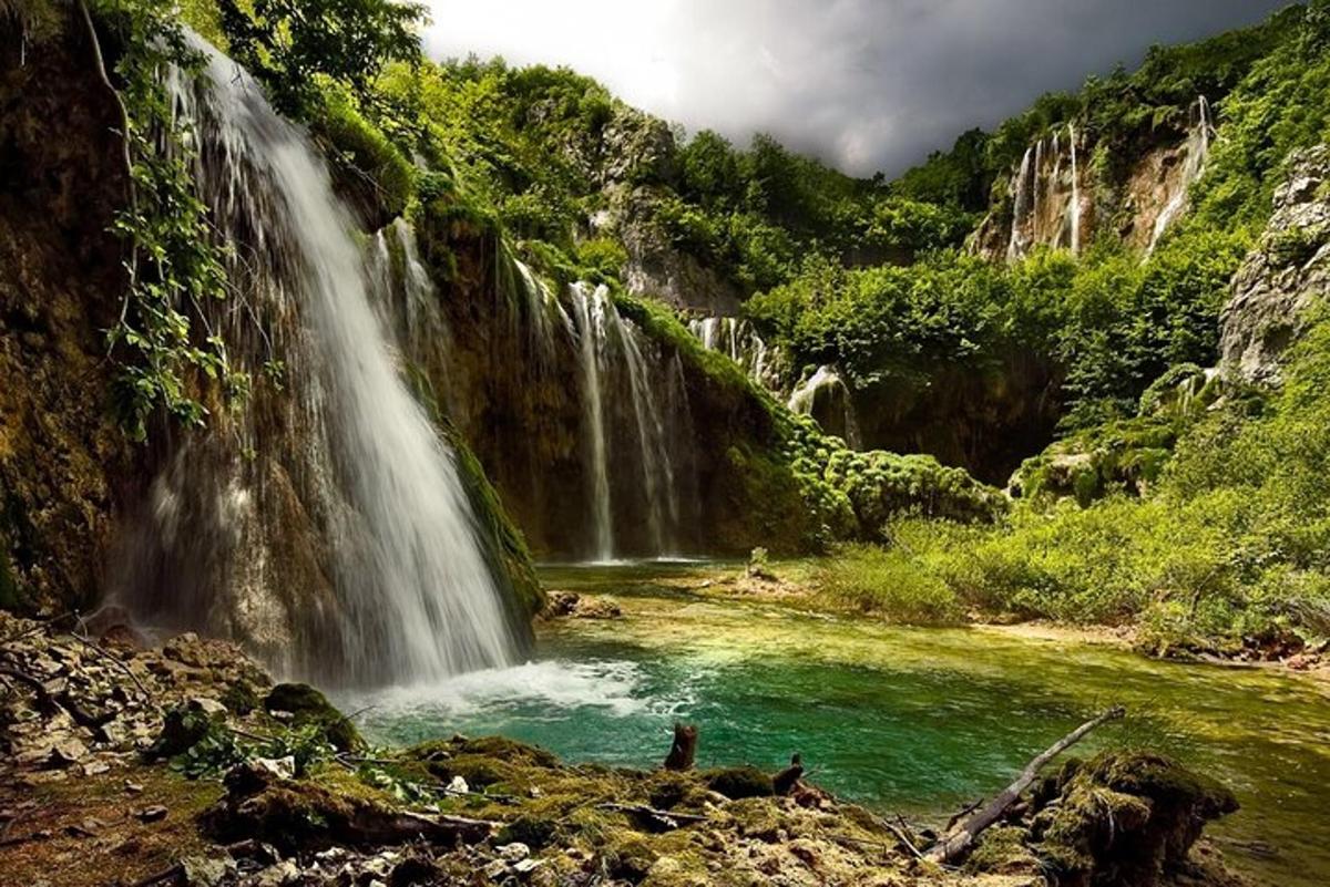 a waterfall in a canyon with a pool of water