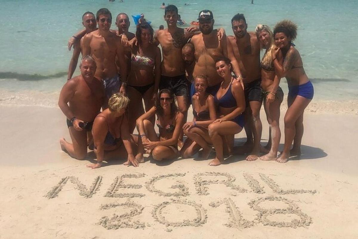 un gruppo di persone in posa per una foto sulla spiaggia