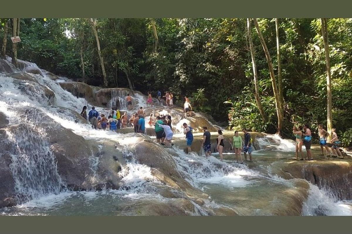 un grup de persones dempeus a l'aigua d'una cascada