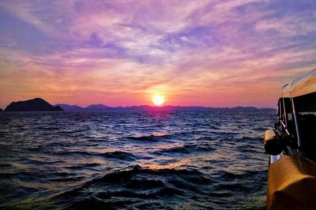 un tramonto da una barca nell'oceano con il sole che tramonta