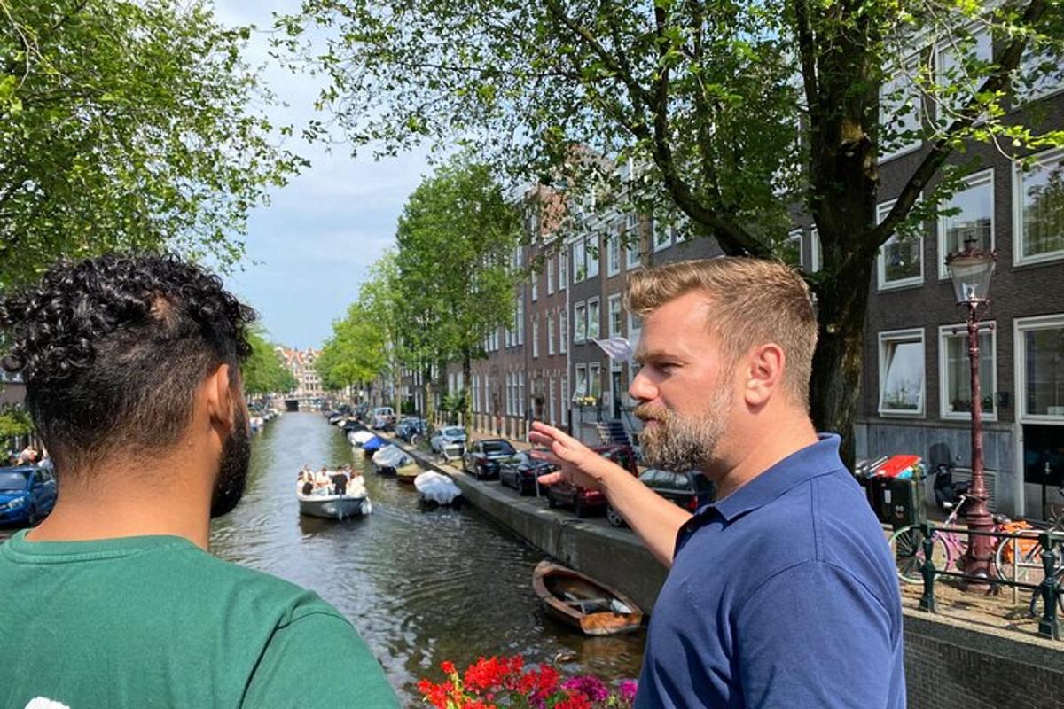 two men standing next to a canal with boats