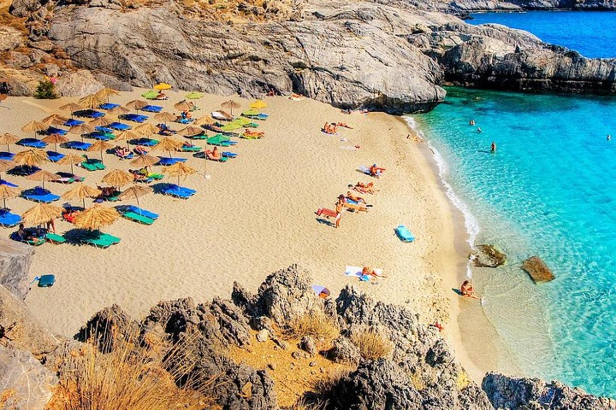 Un grupo de personas tumbadas en una playa con sombrillas.