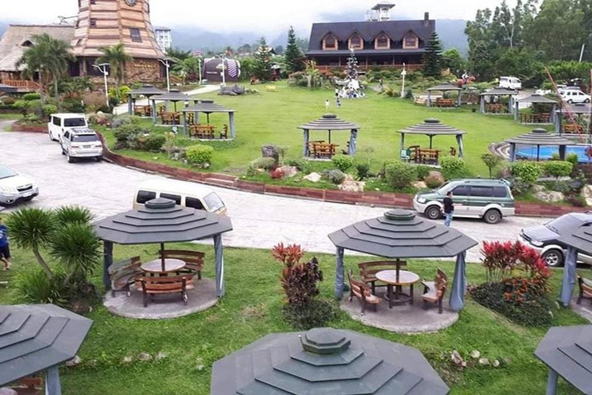 an aerial view of a park with tables and umbrellas