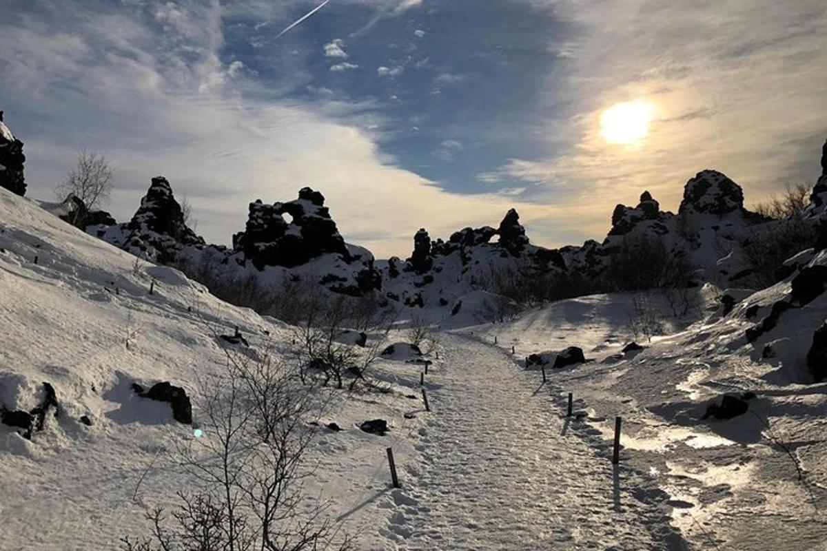 空に太陽が輝く雪に覆われた山