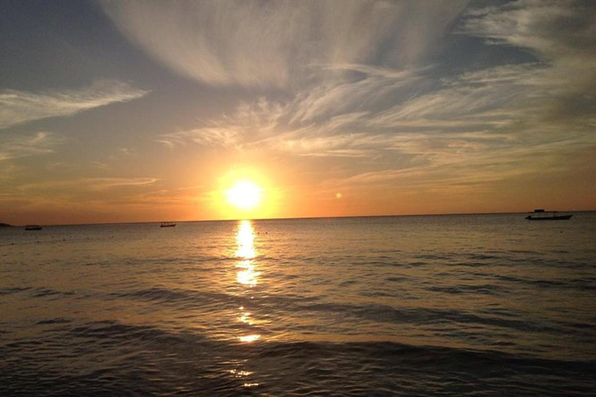 un tramonto sull'oceano con barche in acqua