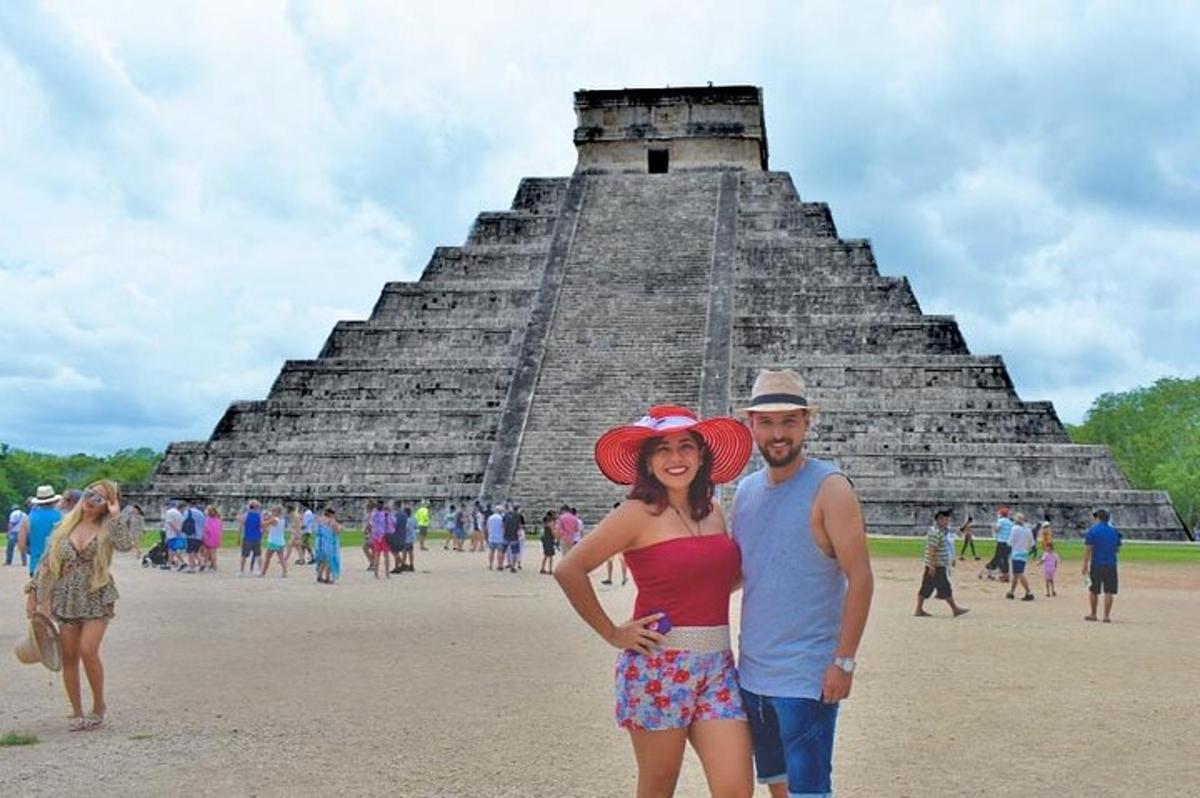 a man and a woman standing in front of a pyramid