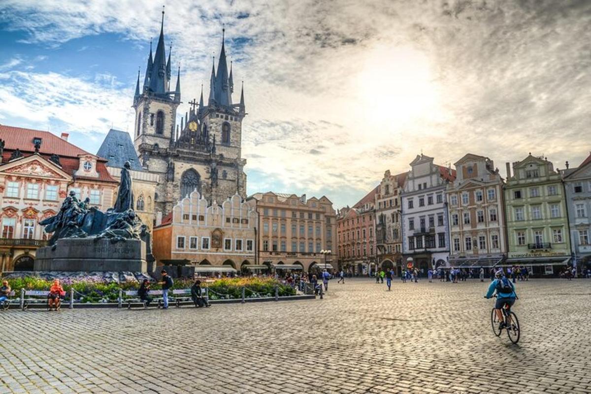 žena jedoucí na kole na náměstí s kostelem