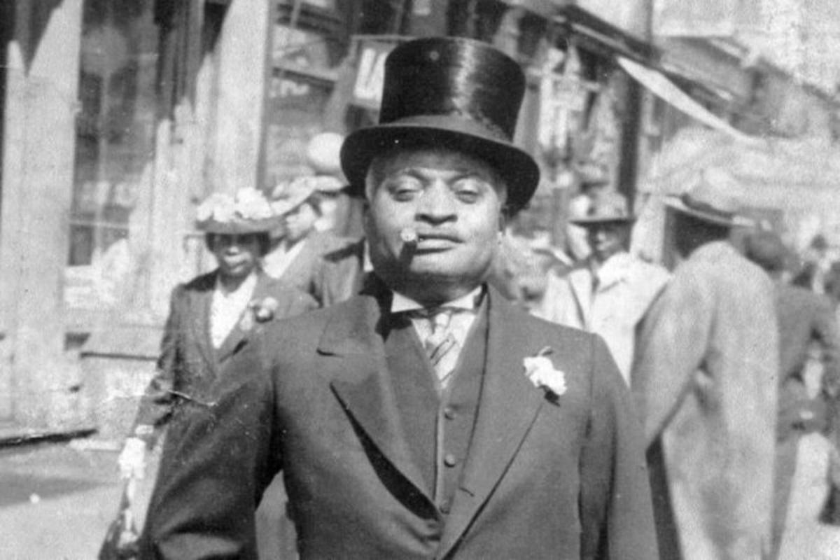 a black and white photo of a man wearing a top hat