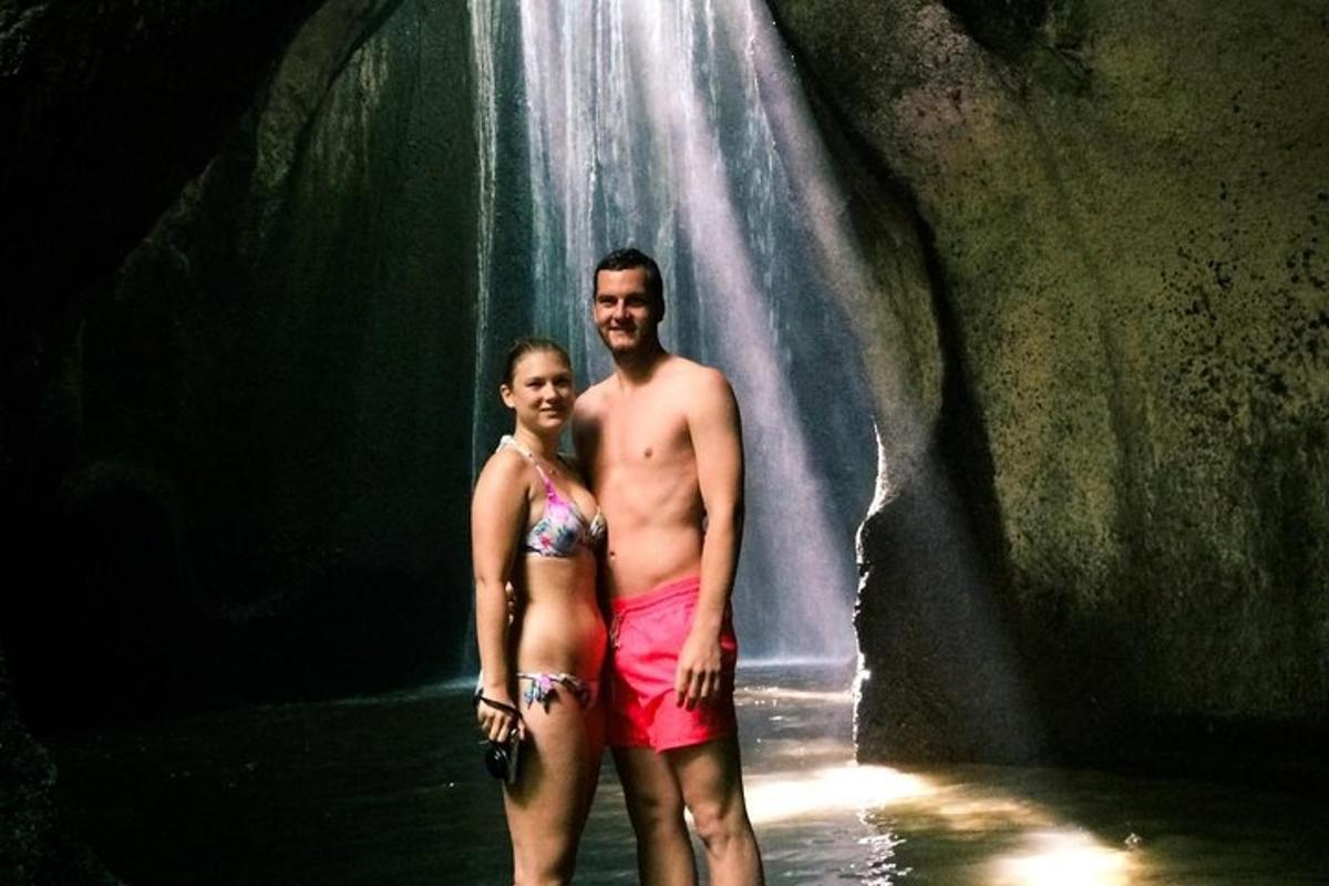 ein Mann und eine Frau stehen vor einem Wasserfall