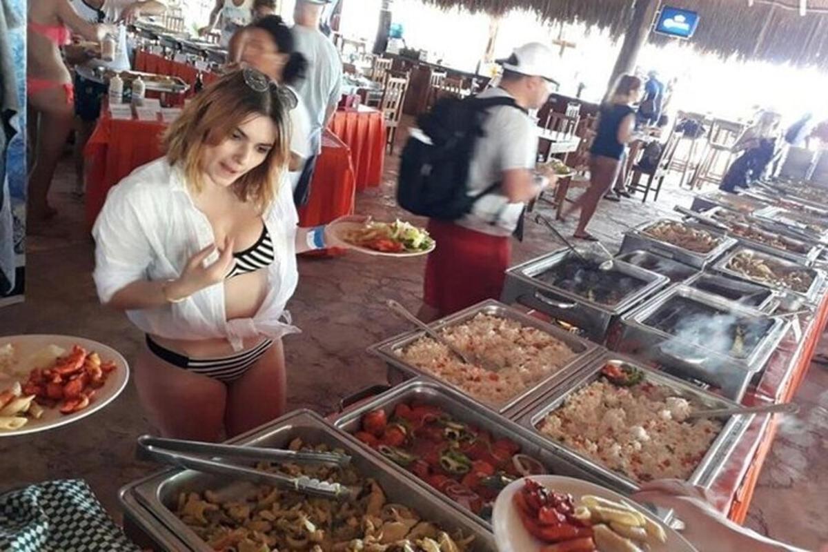 seorang wanita berdiri di hadapan bufet makanan