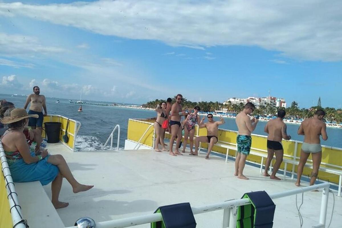 sekumpulan orang berdiri di atas bot di pantai