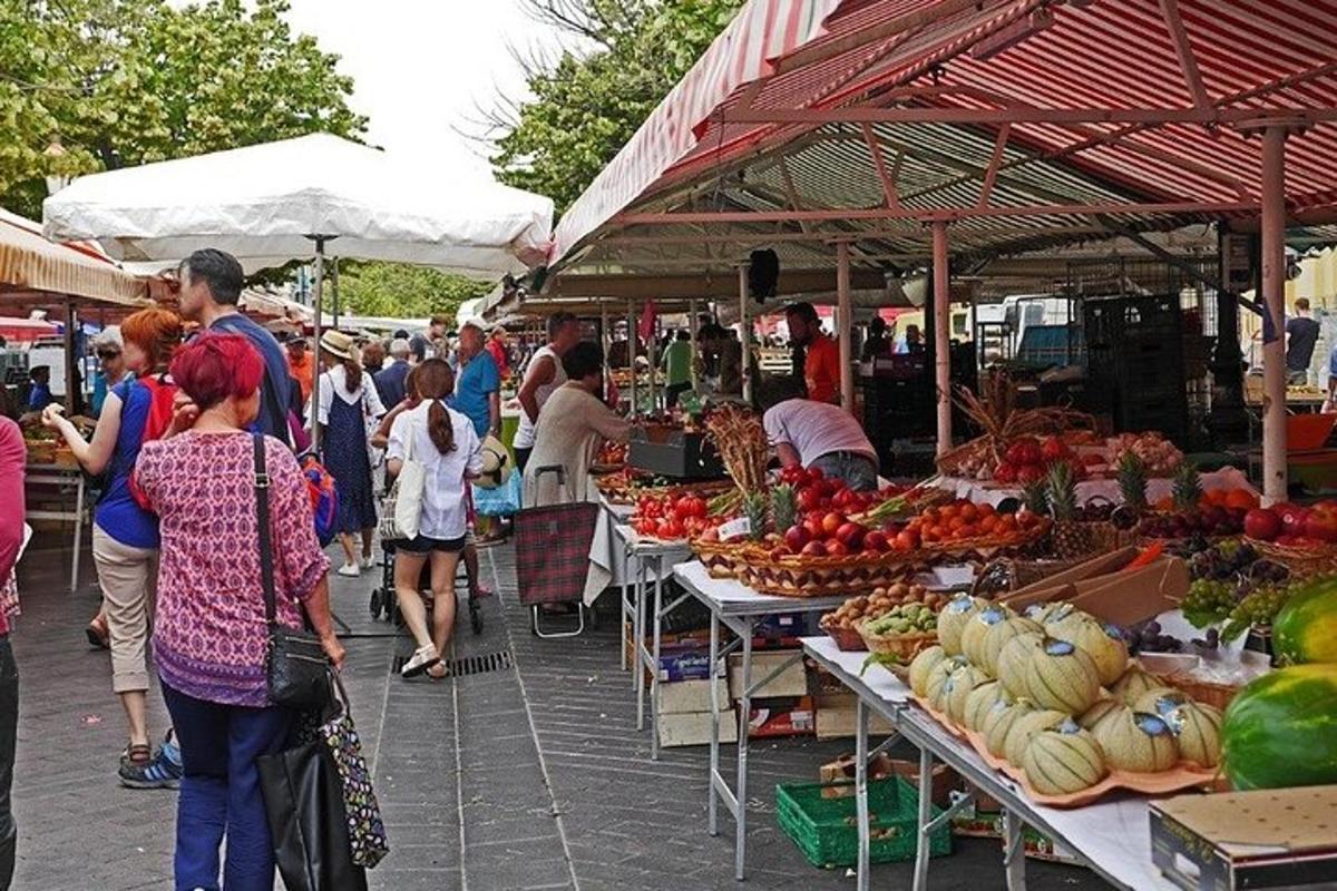 sekumpulan orang berjalan di sekitar pasar dengan buah-buahan dan sayur-sayuran