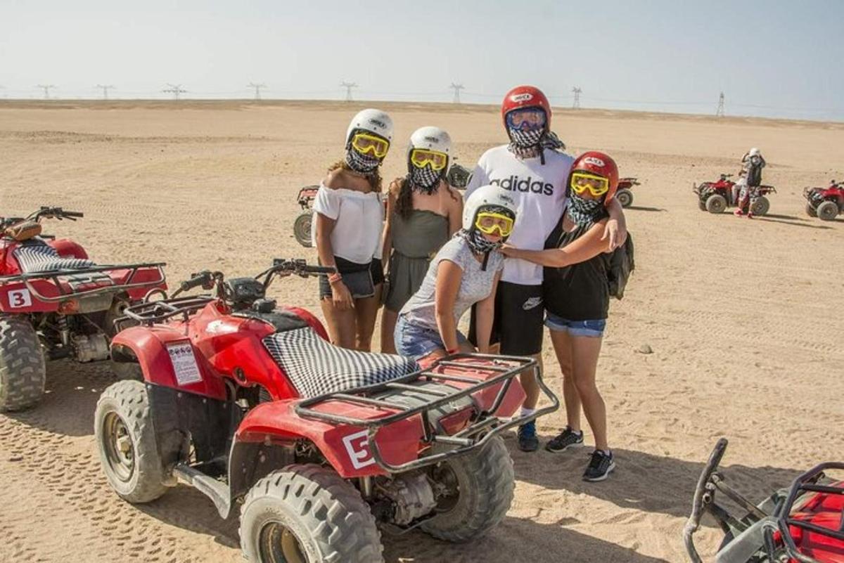 çölde ATV'lerle duran bir grup insan