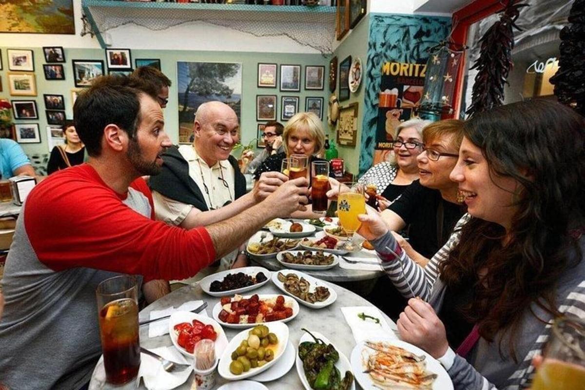 skupina ľudí sediacich okolo stola a jediacich