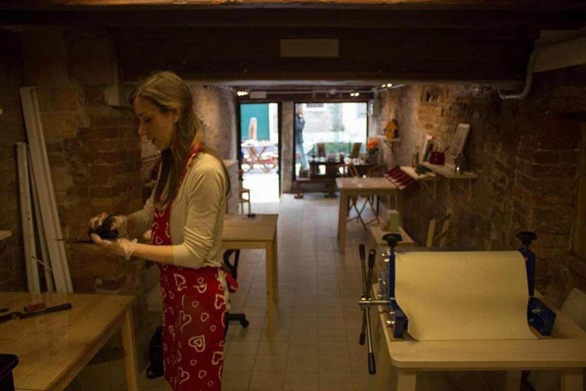 a woman standing in a kitchen looking at her cell phone