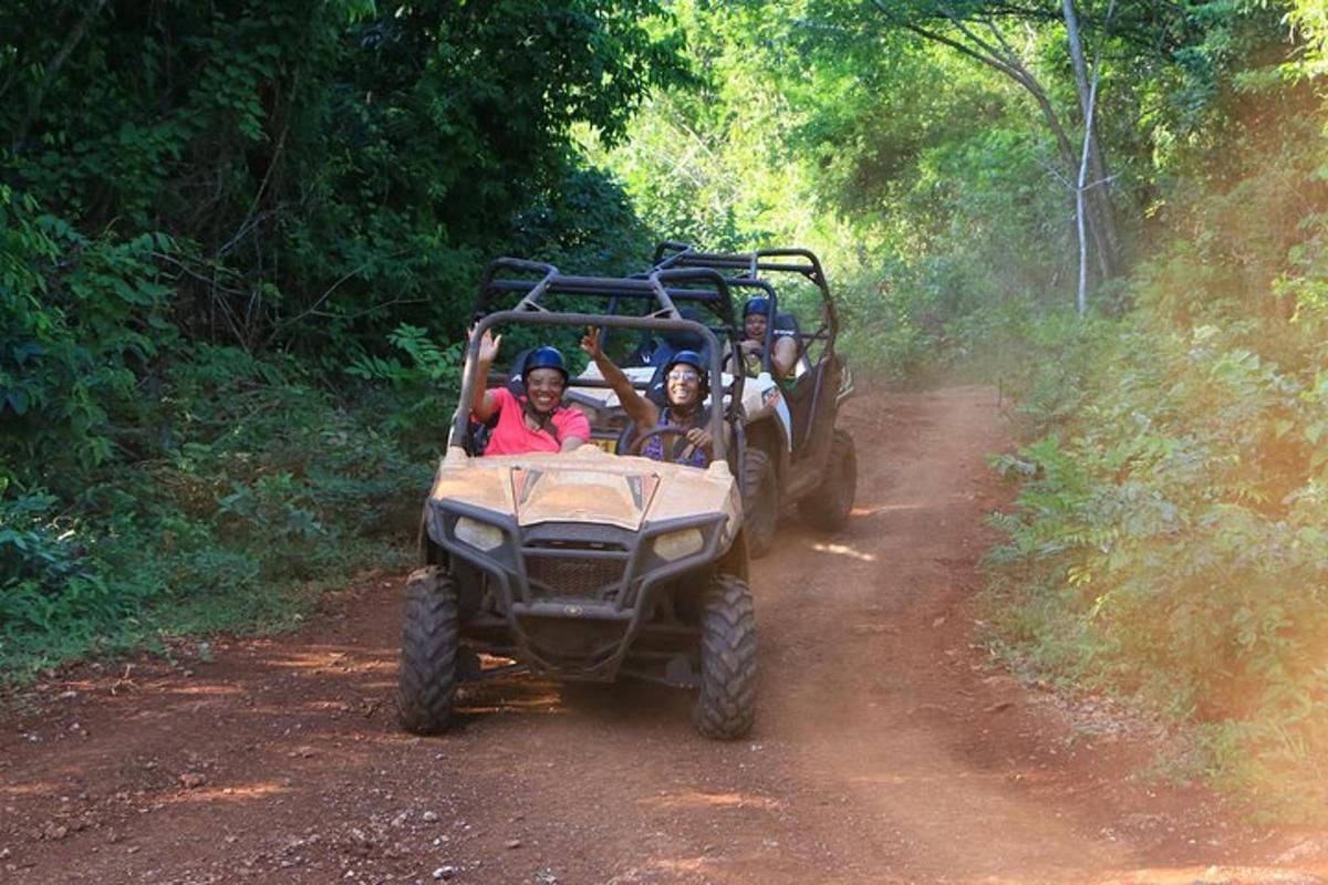a group of people riding in a four wheeler on a dirt road