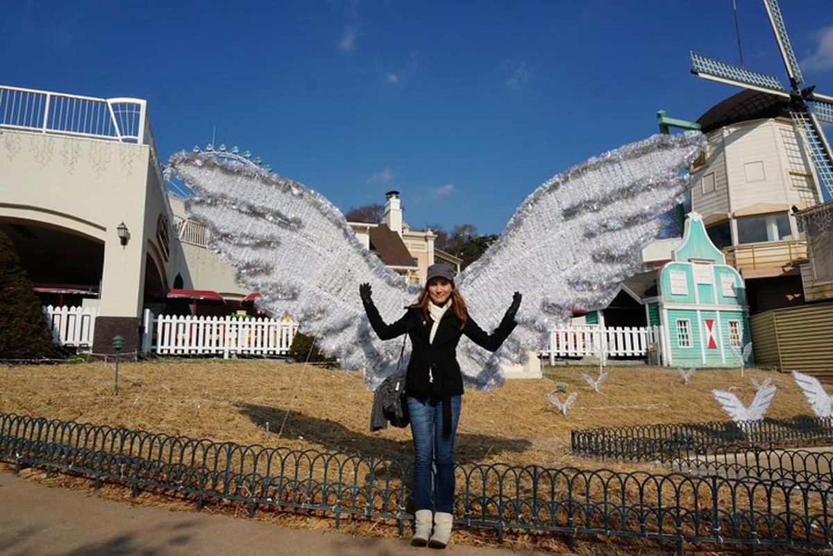 a woman standing with her wings open in front of a windmill