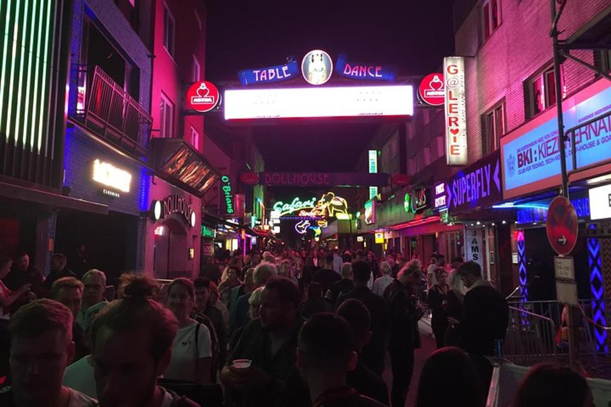 una multitud de personas caminando por una calle de noche
