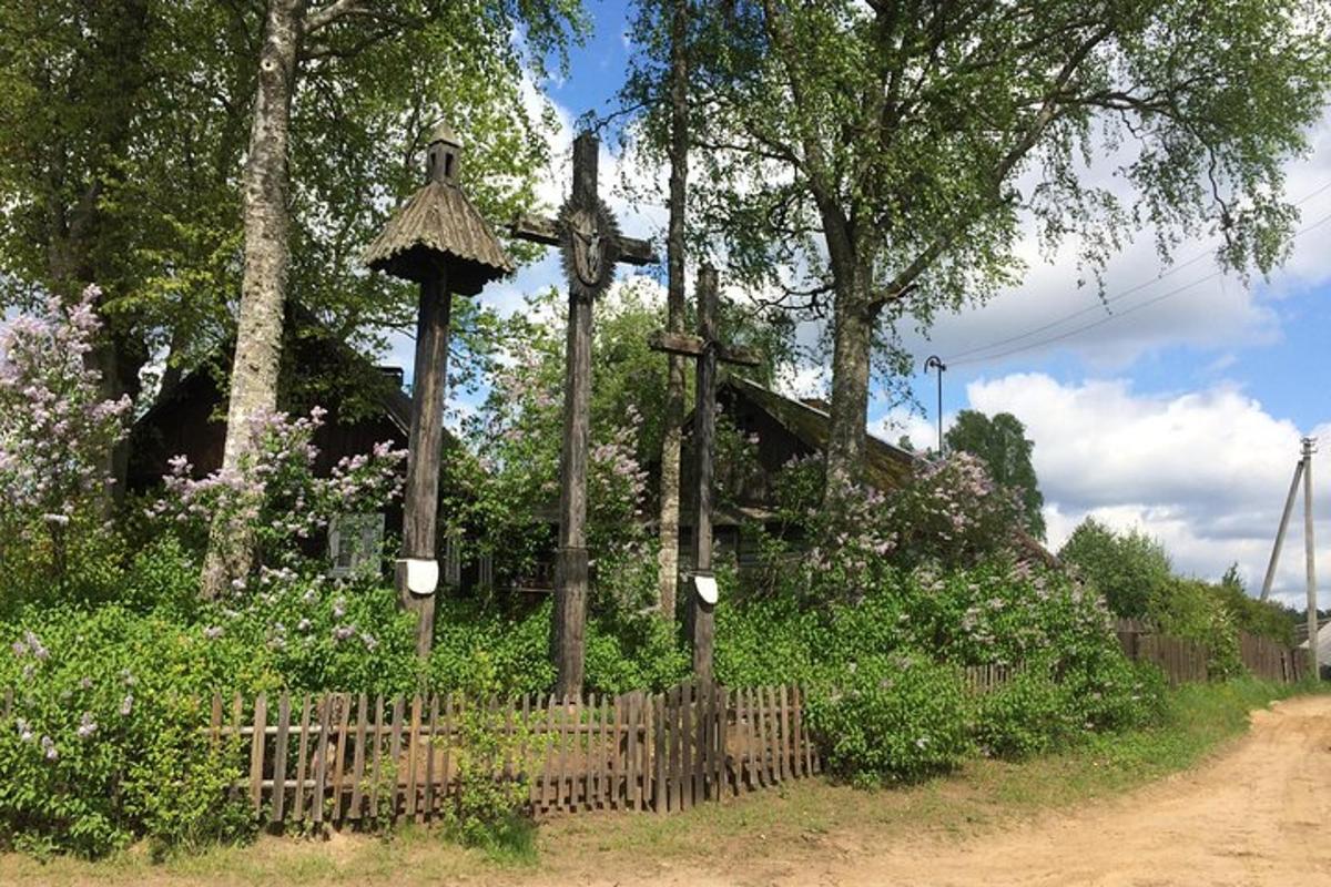 a wooden fence next to a field with flowers