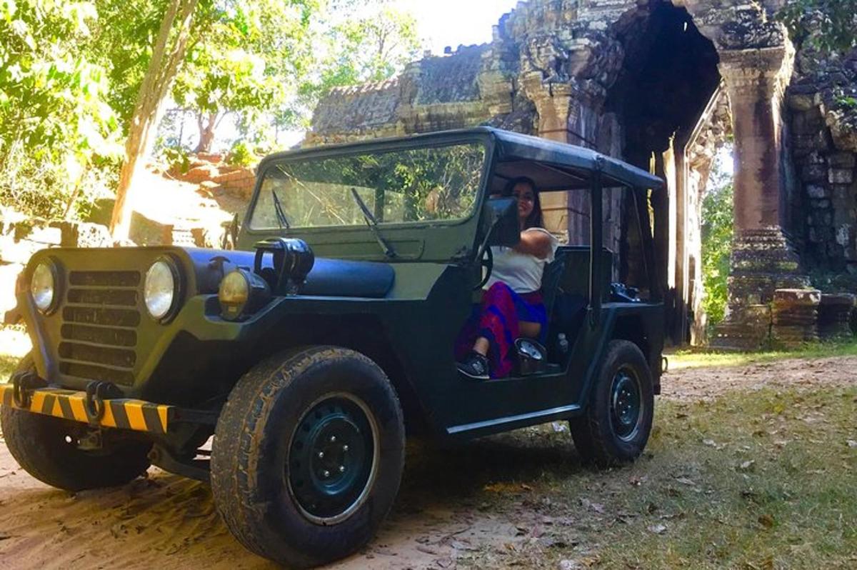 una donna seduta sul retro di una jeep verde