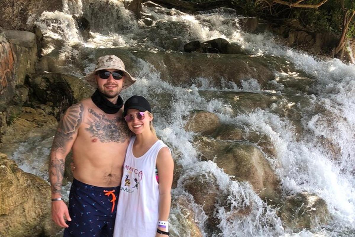 un uomo e una donna in piedi davanti a una cascata