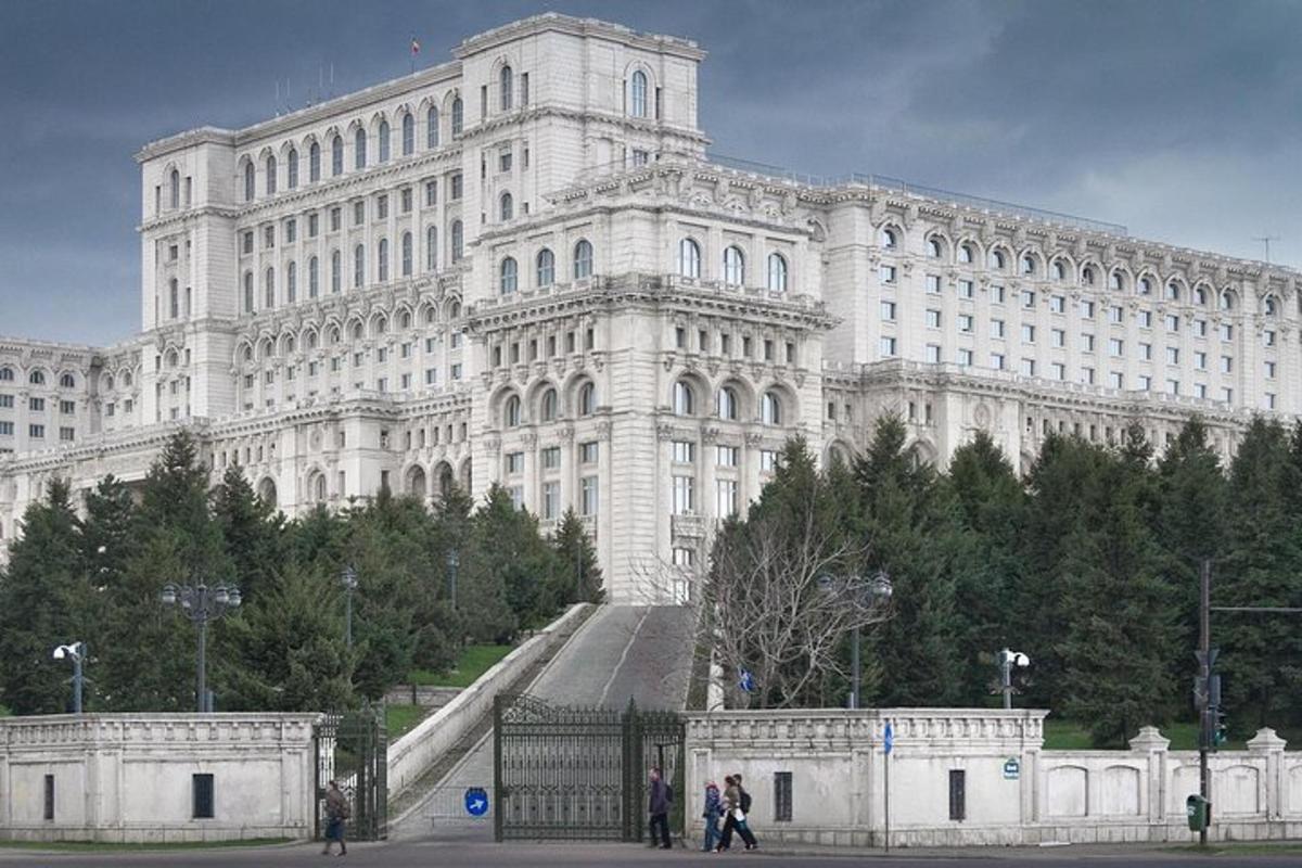 a large white building with people standing in front of it