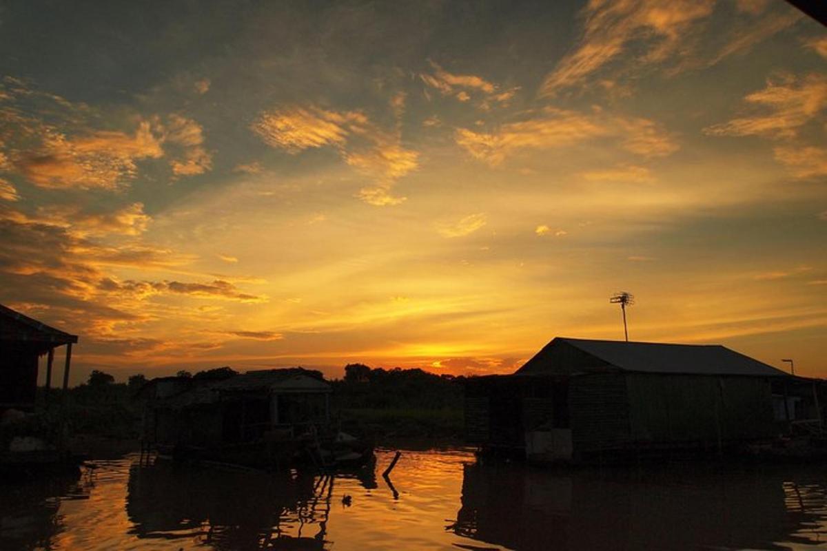 a sunset over a body of water with houses