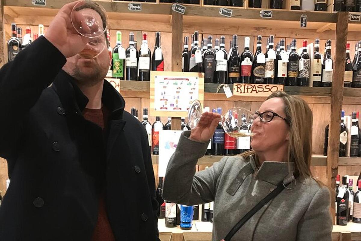 un home i una dona bevent vi en una botiga de vins