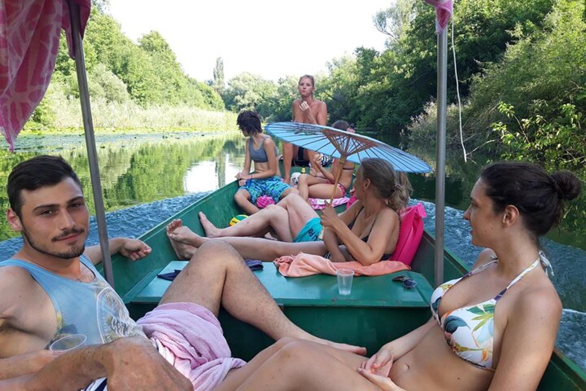 un gruppo di persone sedute su una barca su un fiume